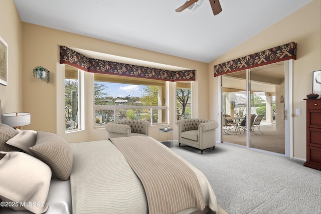 carpeted bedroom featuring access to outside, vaulted ceiling, and a ceiling fan