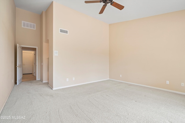 spare room with baseboards, a ceiling fan, visible vents, and light colored carpet