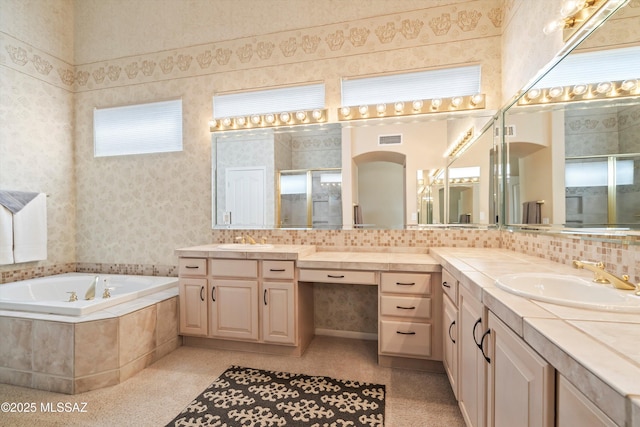 bathroom featuring a bath, visible vents, backsplash, and a sink