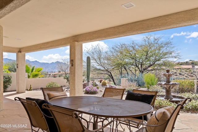 view of patio / terrace featuring a fenced backyard, a mountain view, and outdoor dining space