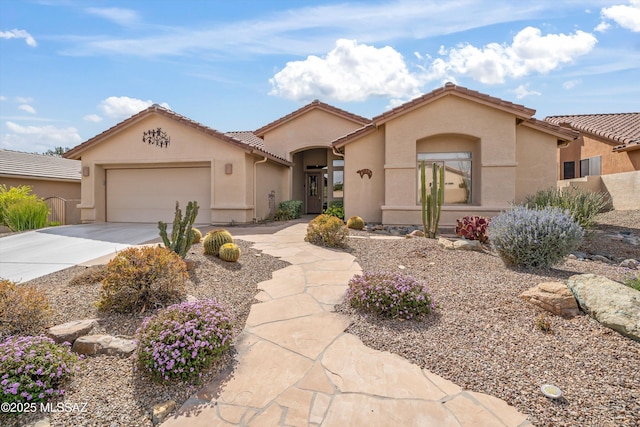 mediterranean / spanish-style house featuring an attached garage, driveway, a tiled roof, and stucco siding