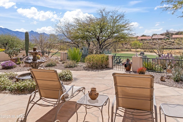 view of patio / terrace featuring fence and a mountain view