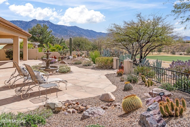 view of patio / terrace featuring fence and a mountain view