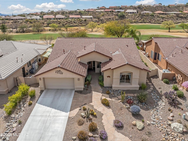 view of front facade with a garage, concrete driveway, a tile roof, and stucco siding