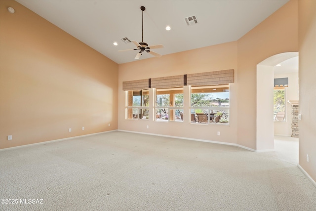 spare room with carpet floors, arched walkways, and visible vents