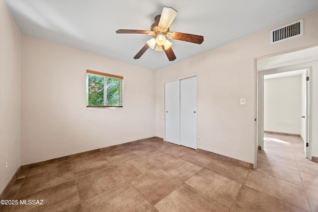 unfurnished bedroom featuring a ceiling fan, baseboards, visible vents, and a closet