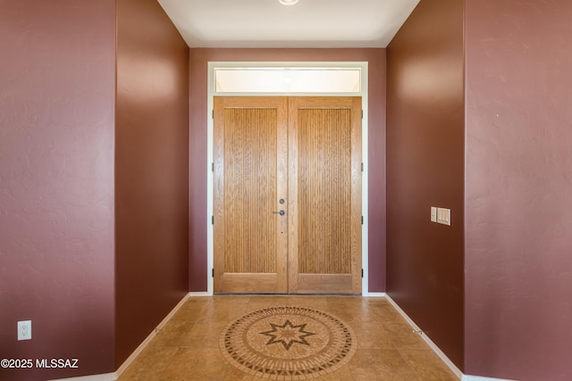 doorway featuring baseboards and tile patterned floors