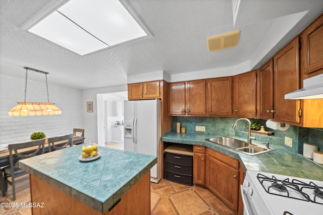 kitchen with white appliances, visible vents, a sink, brown cabinets, and backsplash