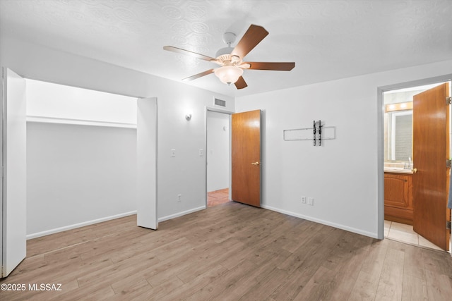 unfurnished bedroom with visible vents, baseboards, connected bathroom, and light wood finished floors