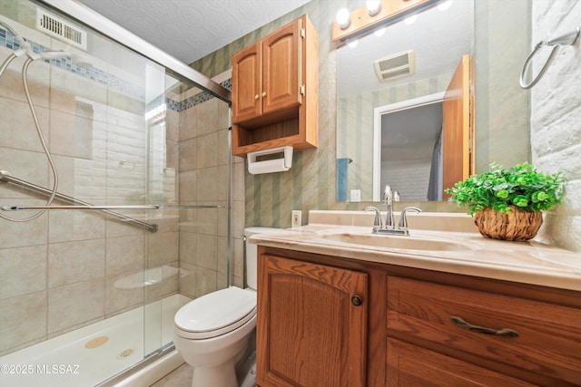 bathroom featuring visible vents, toilet, a stall shower, wallpapered walls, and vanity