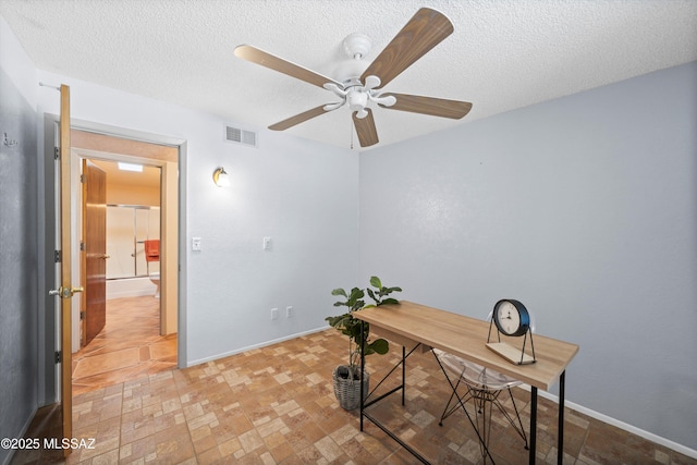 office space featuring visible vents, ceiling fan, a textured ceiling, and baseboards