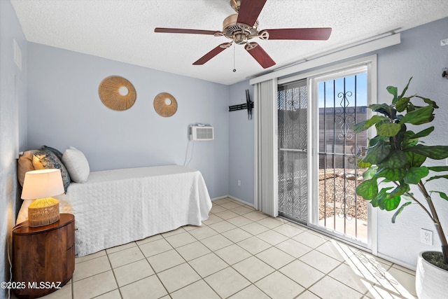 bedroom with light tile patterned floors, a wall mounted air conditioner, and a textured ceiling