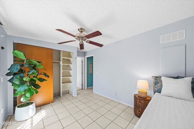 bedroom with light tile patterned floors, visible vents, and a textured ceiling