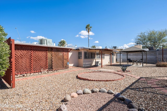 rear view of house featuring a gazebo, a patio area, and fence