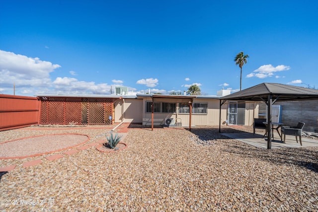 rear view of house with a gazebo, fence, and a patio area