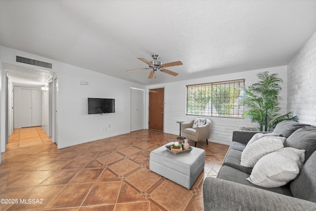 living area with light tile patterned flooring, visible vents, and ceiling fan