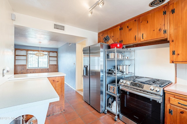 kitchen featuring pendant lighting, visible vents, light countertops, appliances with stainless steel finishes, and brown cabinetry