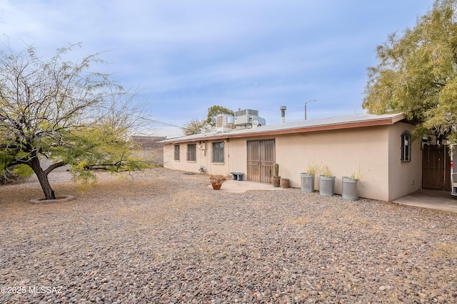 back of property featuring stucco siding