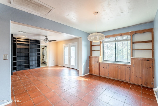 tiled empty room featuring built in features, french doors, visible vents, and plenty of natural light