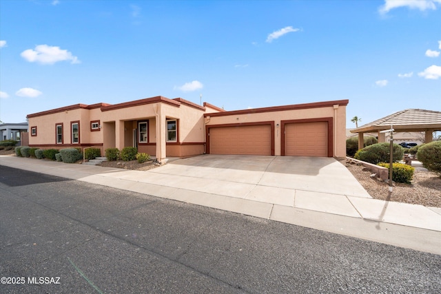 view of front facade featuring stucco siding, driveway, and a garage
