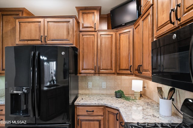 kitchen with backsplash, black appliances, and brown cabinets