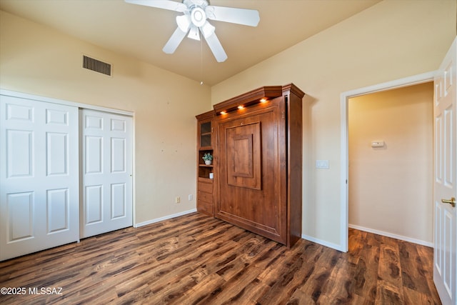 unfurnished bedroom with visible vents, baseboards, a closet, and dark wood-style flooring