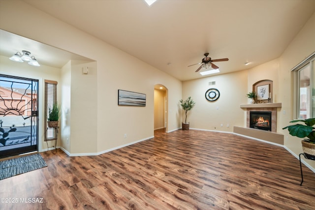 foyer with a wealth of natural light, baseboards, wood finished floors, and a tile fireplace
