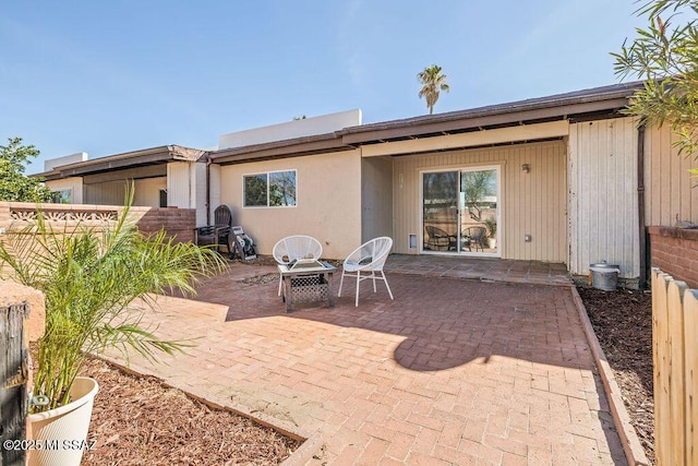 rear view of house featuring fence and a patio