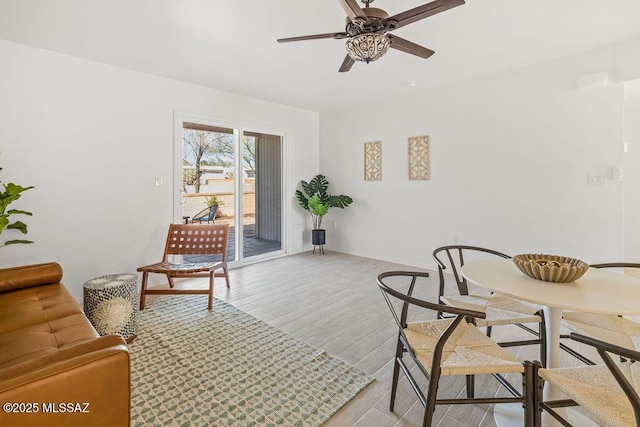 living area with light wood-type flooring and a ceiling fan