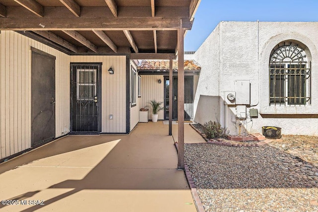 entrance to property with a patio area and a tiled roof