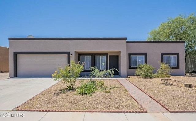 southwest-style home with driveway, a garage, and stucco siding