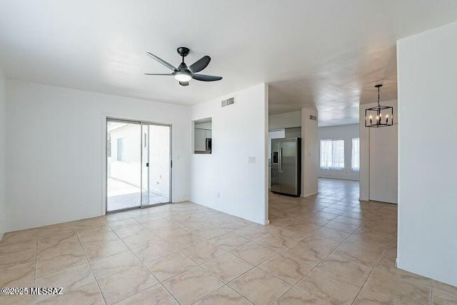 empty room featuring visible vents and ceiling fan with notable chandelier