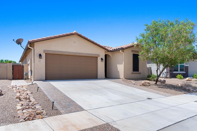 view of front of house featuring a garage, concrete driveway, a tile roof, and stucco siding