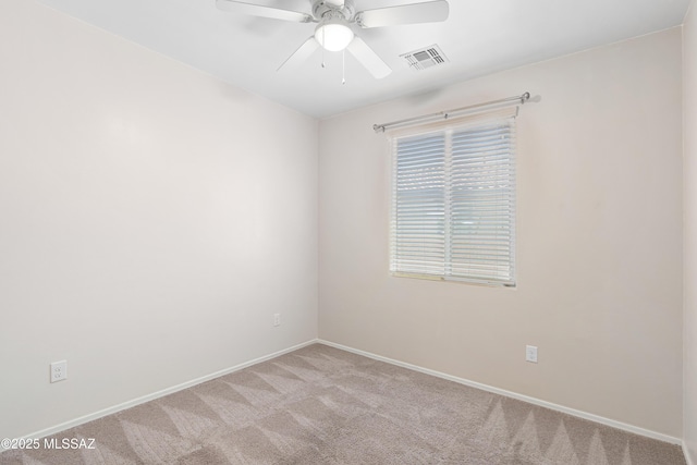 spare room with light carpet, baseboards, visible vents, and a ceiling fan