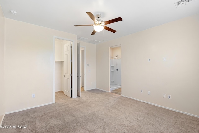 unfurnished bedroom with baseboards, a spacious closet, visible vents, and light colored carpet