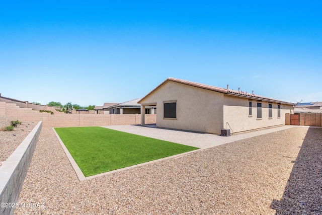 back of property featuring a fenced backyard, a tiled roof, a patio, and stucco siding