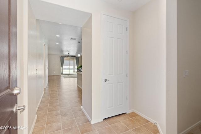corridor with visible vents, baseboards, and light tile patterned floors