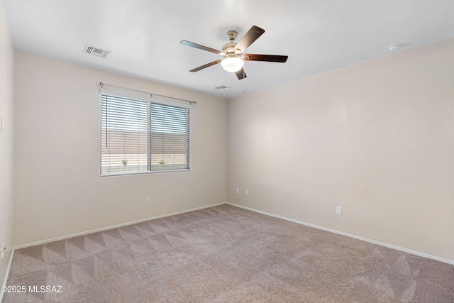 empty room with baseboards, a ceiling fan, visible vents, and light colored carpet