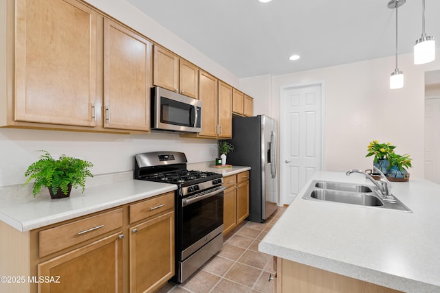 kitchen with appliances with stainless steel finishes, light countertops, a sink, and hanging light fixtures