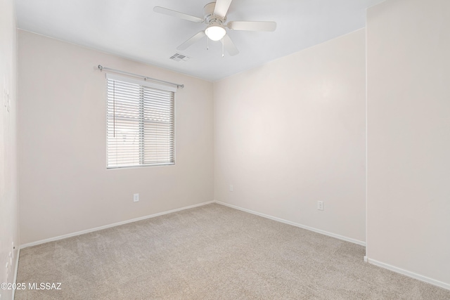 empty room with light colored carpet, visible vents, ceiling fan, and baseboards