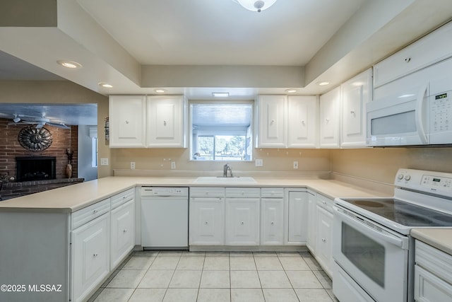 kitchen with light countertops, white appliances, white cabinetry, and a sink