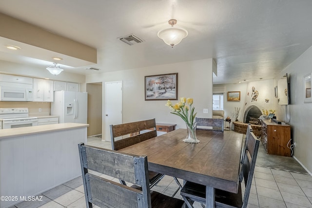 dining area featuring light tile patterned floors and visible vents