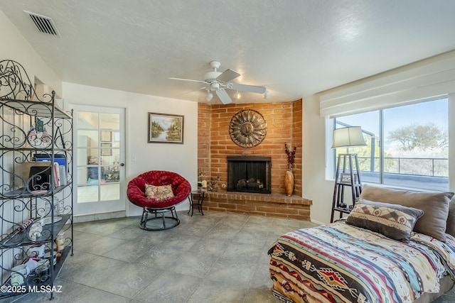 bedroom with a textured ceiling, a fireplace, visible vents, and access to exterior