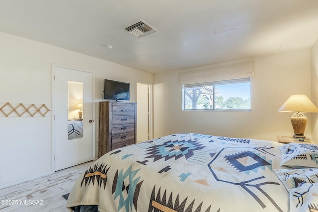 bedroom featuring visible vents and wood finished floors