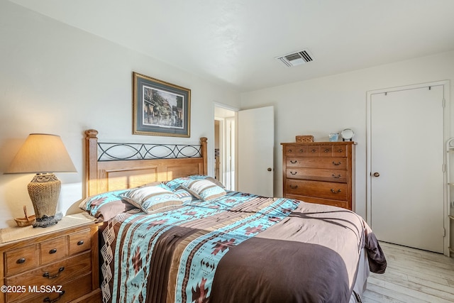 bedroom with light wood finished floors and visible vents