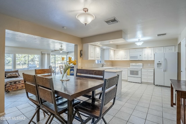 dining area featuring light tile patterned floors, visible vents, and a ceiling fan