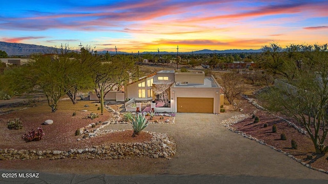 view of front of home with driveway, a mountain view, and stucco siding