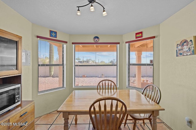 dining room featuring a textured ceiling and light tile patterned flooring