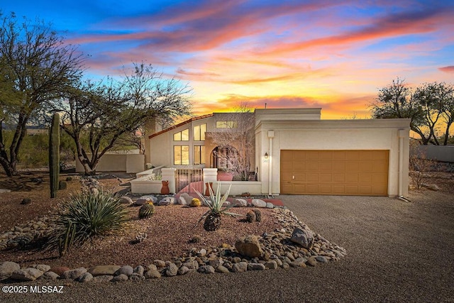 view of front facade with a garage, decorative driveway, and stucco siding