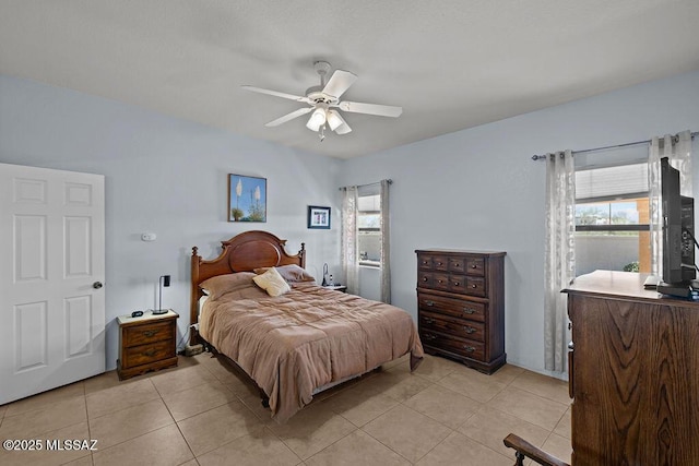 bedroom featuring multiple windows, ceiling fan, and light tile patterned flooring